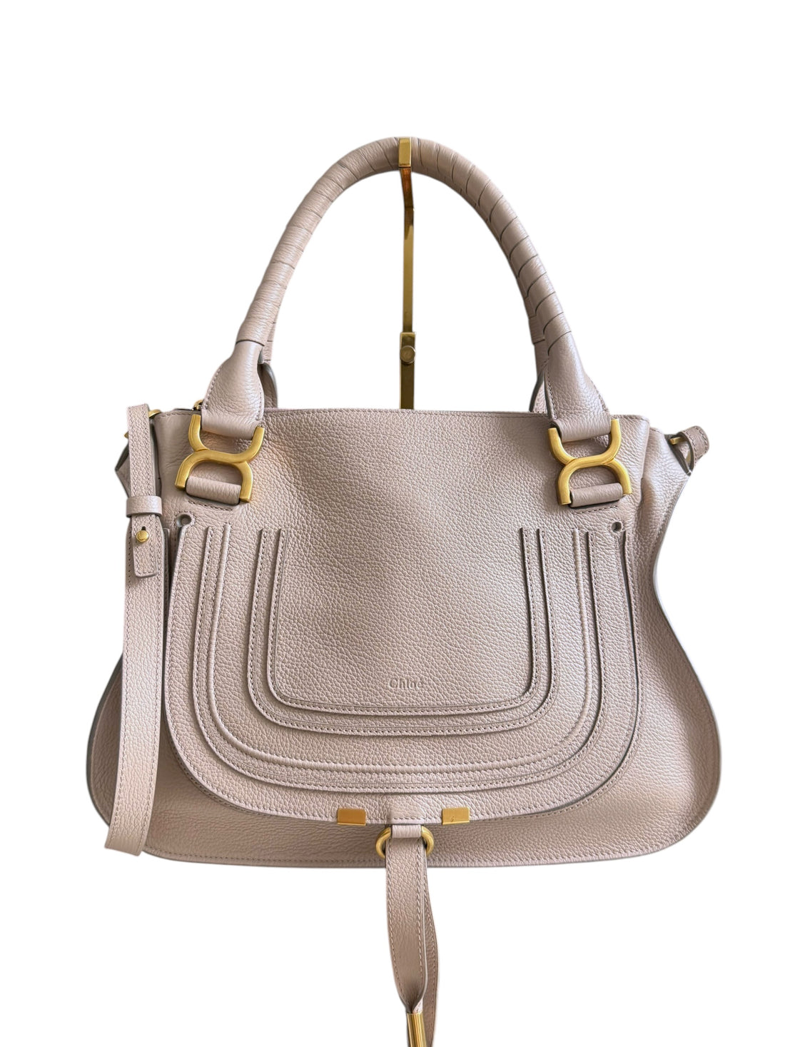 Chloé Marcie Bag in einem santen Nude- bzw. Beigerosa-Ton aus genarbtem Kalbsleder mit charakteristischen handgewickelten Henkeln und goldfarbenen Metallbeschlägen.