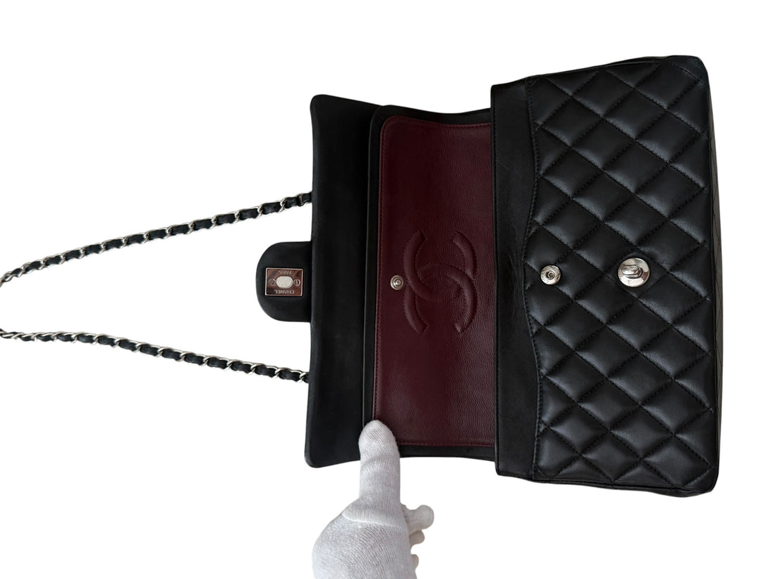 CHANEL Medium Classic Double Flap Bag aus schwarzem Lammleder und silberfarbener Hardware.