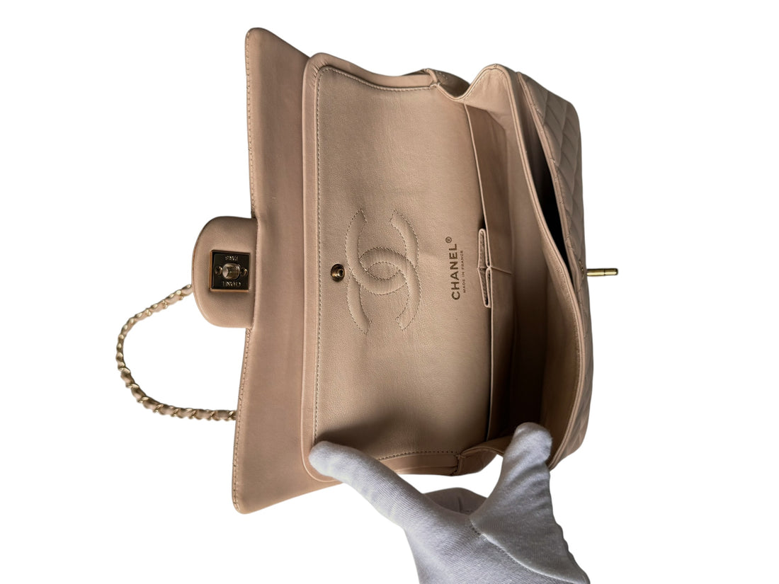 Chanel Classic Medium Double Flap Bag ist aus beigem Lammleder gefertigt und verfügt über eine charakteristische Rautensteppung. Goldfarbene Hardware