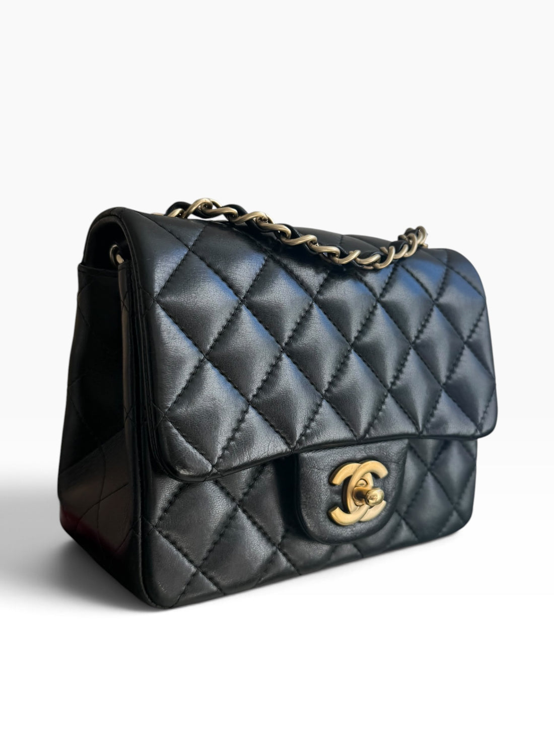 Chanel Classic Flap Bag Mini Square aus schwarzem Lammleder mit goldfarbenem Metall.