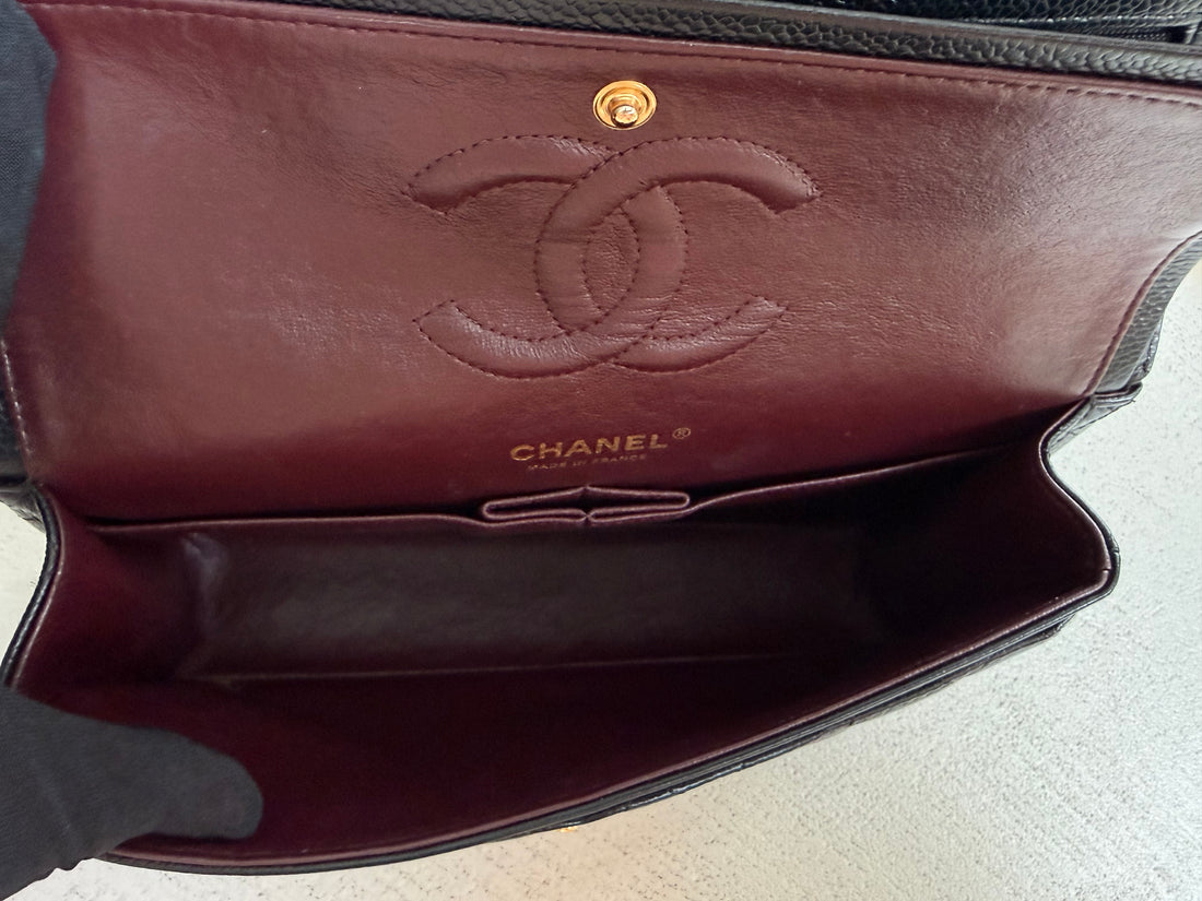 Sac Classic Double Flap moyen CHANEL en cuir caviar noir et bijouterie dorée.