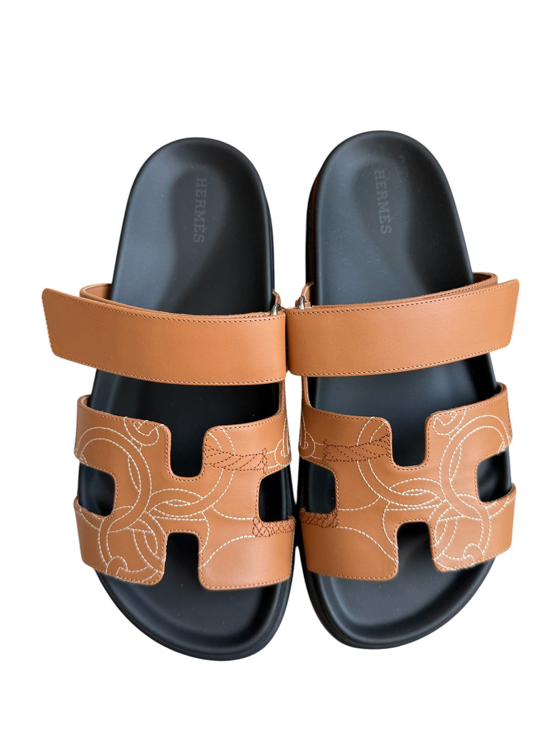 Hermès Chypre Sandalen in der Farbe Naturel sind aus Kalbsleder gefertigt und zeichnen sich durch die aufwendige „Panoplie Equestre“-Stickerei sowie das markentypische, breite H-Design aus. Grösse 39.